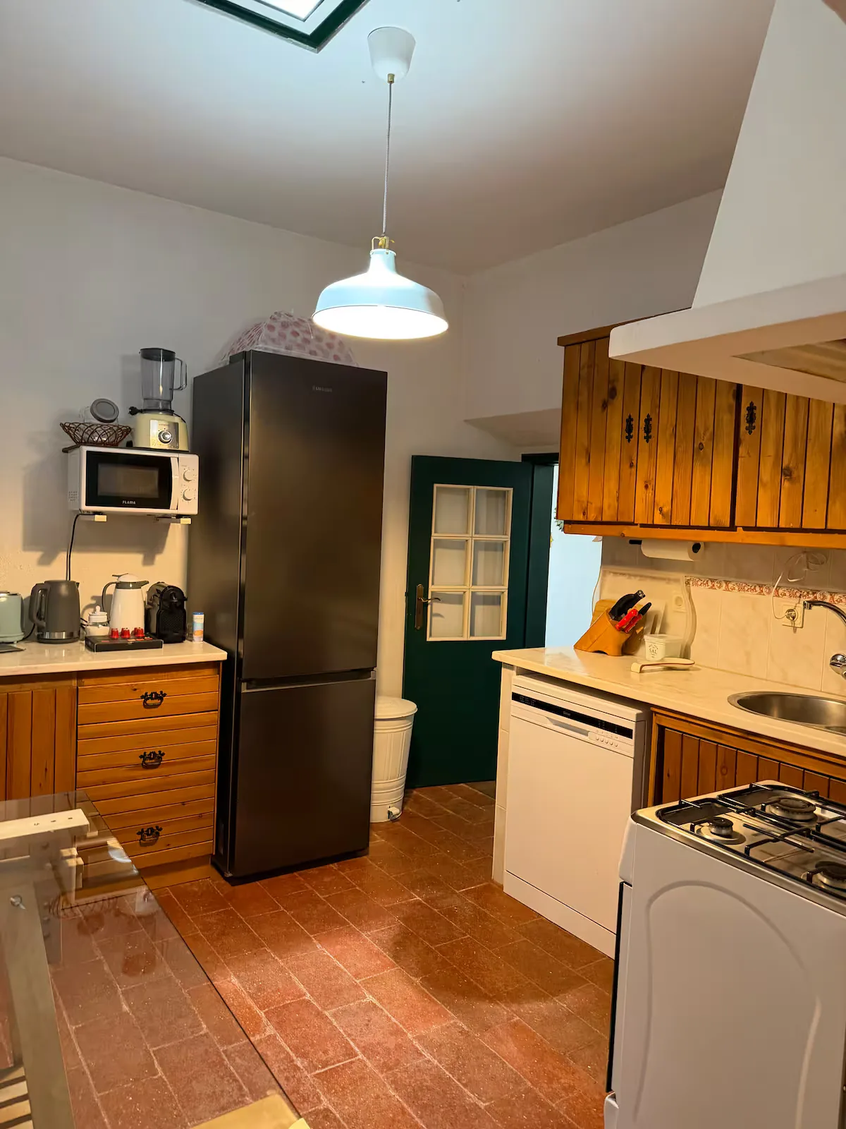 Cozinha equipada com frigorífico e micro-ondas