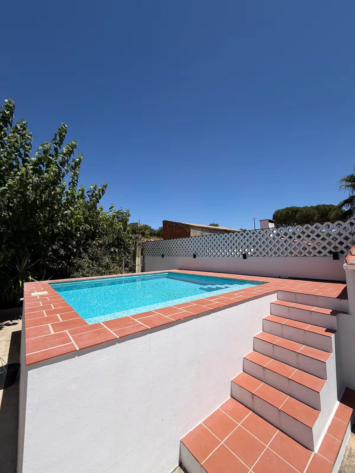 Escadas de tijoleira que descem para a piscina