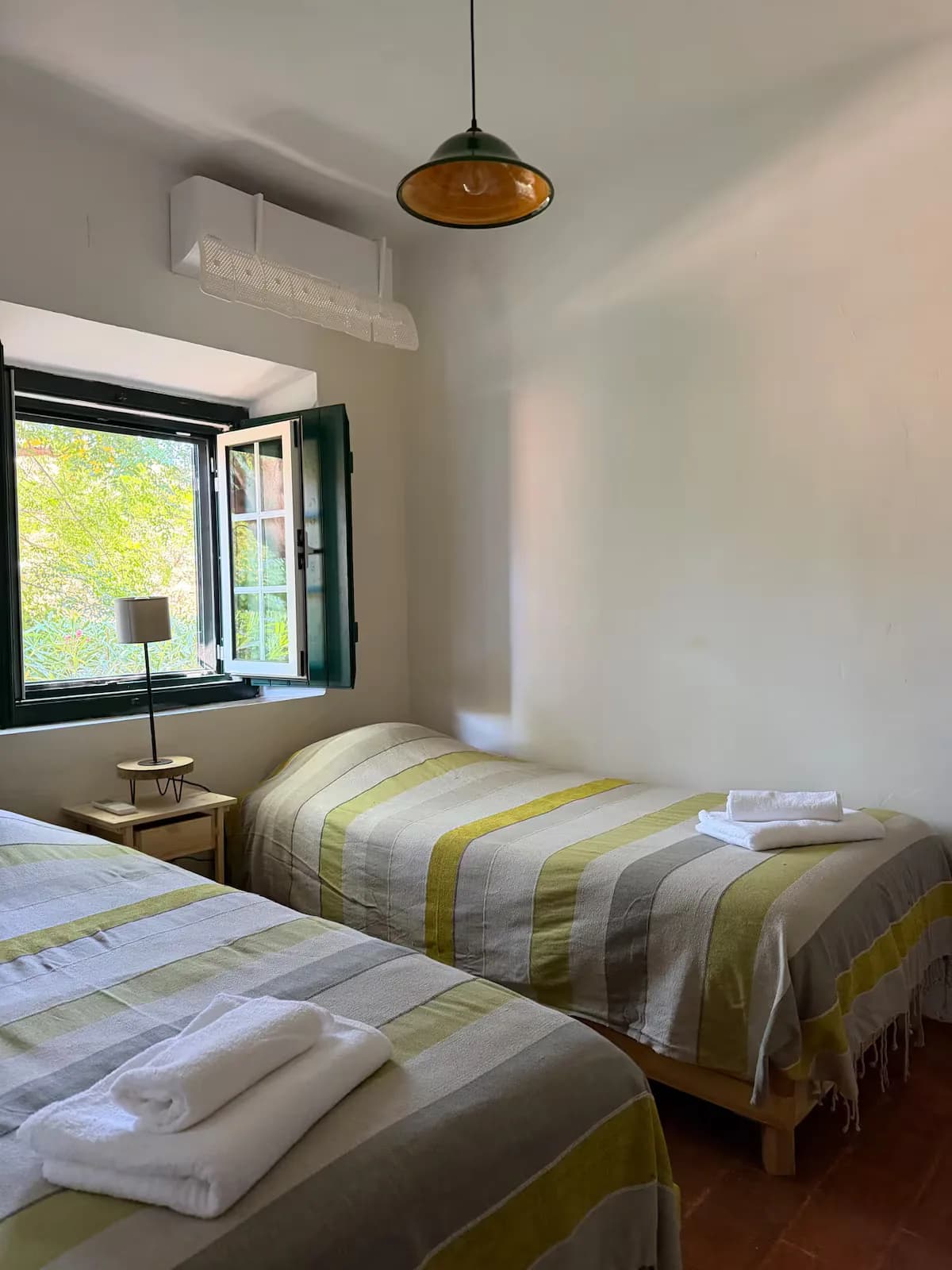Quarto com duas camas individuais e toalhas preparadas
